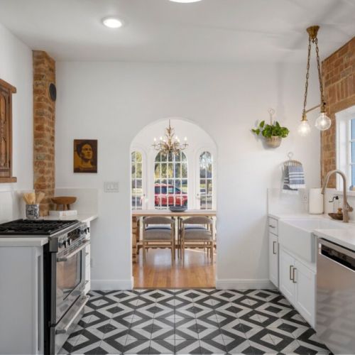 Modern kitchen with original hardware and exposed brick.