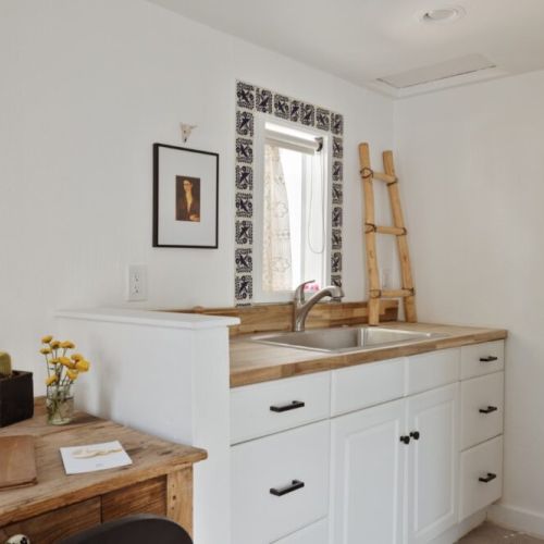 Warm and welcoming kitchenette with natural wood accents and hand-painted tile details.