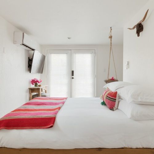 Wake up to soft natural light and vibrant designs at The Frida, a serene space designed for rest, comfort, and style.