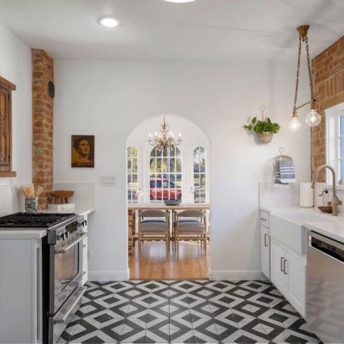 Modern kitchen with original hardware and exposed brick.