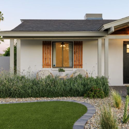 Greenery and a small seating area by the front patio