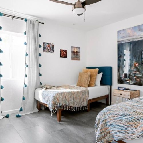 3rd bedroom with twin beds, TV and natural lighting.