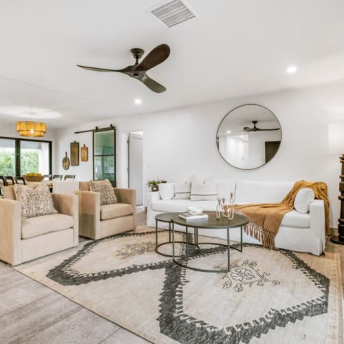 Restoration Hardware vibes with plush seating and warm lighting.